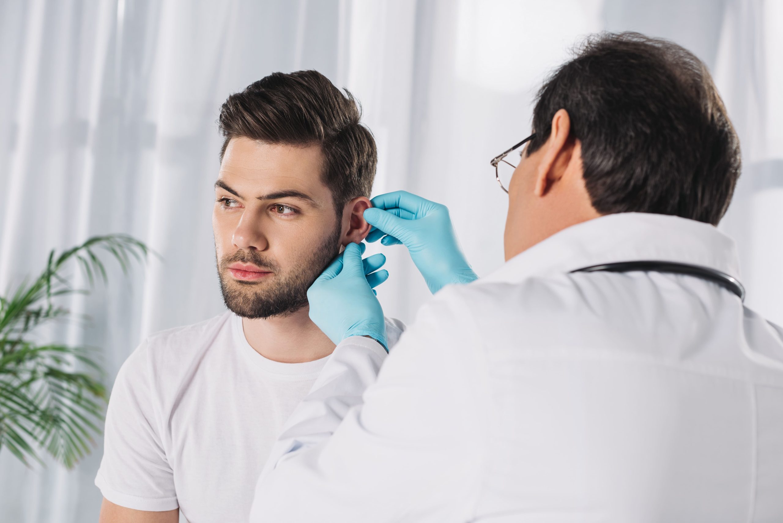 doctor-examining-male-patient-ear-2023-11-27-04-54-32-utc